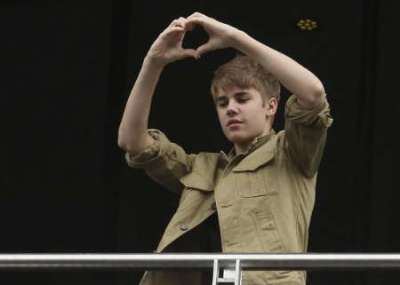 Canadian pop singer Justin Bieber greets his fans from the balcony of his hotel before leaving for his first 'My World Tour' concert at the Foro Sol in Mexico City October 1, 2011.