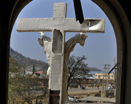 A damaged crucifix overlooks the scene of a bomb explosion at St. Theresa Catholic Church at Madalla, Suleja, just outside Nigeria's capital Abuja, on Dec. 25, 2011. Five bombs exploded on Christmas Day at churches in Nigeria.