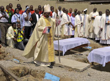 Clergymen gather around the coffins of the victims of the Christmas day bombing at St Theresa Catholic Church Madalla, during a mass funeral for the victims, outside Nigeria's capital Abuja February 1, 2012. Islamist sect Boko Haram claimed responsibility for the bombing of St. Theresa Catholic Church in Madalla, on the outskirts of Abuja, which killed 37 people and wounded 57.