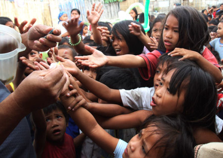 Children reach to get a stub for free meals during a feeding program funded by a South Korean missionary at a slum area at Baseco, Tondo city, metro Manila January 31, 2012. Survey results from the Social Weather Stations (SWS) reflected an increase in the number of Filipino families who claimed they experienced involuntary hunger, from 4.3 million to 4.5 million last September, local media reported.