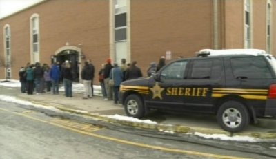 Police and students look over the scene of a shooting at Chardon High School in Chardon, Ohio February 27, 2012. A gunman, believed to be a student, opened fire at the high school east of Cleveland, wounding four students before he was taken into custody, officials said.