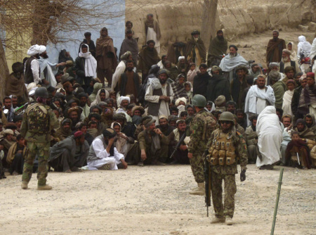 Afghan National Army soldiers keep watch as Afghans gather outside a U.S. base in Panjwai district Kandahar province, March 11, 2012. A rogue US soldier killed 16 civilians in a shooting spree in Afghanistan's southern Kandahar province on Sunday, in an incident likely to deepen the growing divide between Washington and Kabul.