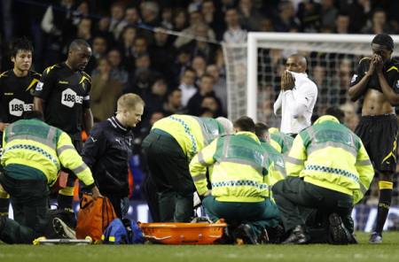 Bolton Wanderers players look on as medical staff attend to Fabrice Muamba after he collapsed on the pitch during their FA Cup quarter-final soccer match against Tottenham Hotspur at White Hart Lane in London March 17, 2012.