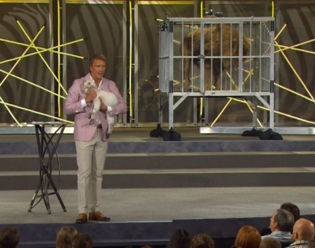 Pastor Ed Young of Fellowship Church in Grapevine, Texas, holds a lamb near a cage with a live lion during his Easter 'Wild' sermon on April 8, 2012.