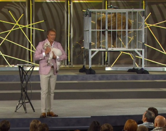 Pastor Ed Young of Fellowship Church in Grapevine, Texas, holds a lamb near a cage with a live lion during his Easter 'Wild' sermon on April 8, 2012.