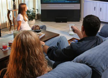 A family watches television in an undated photo.