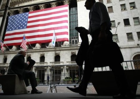 Morning commuters are seen outside the New York Stock Exchange, July 30, 2012.