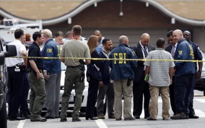 Law enforcement officers confer outside the Family Research Council office after a shooting in Washington August 15, 2012. A gunman wounded a security guard at the headquarters of the conservative Christian lobbying group, police said. Other guards wrestled the gunman to the ground and he was taken into custody. The wounded guard was taken to a hospital, where he is reportedly in stable condition.