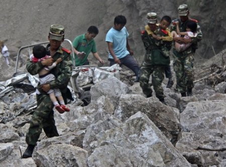 Soldiers carry children as locals follow them towards safer area after two earthquakes hit Zhaotong, Yunnan province, Sept. 7, 2012. Two shallow 5.6 magnitude earthquakes hit mountainous southwestern China on Friday, killing at least 64 people and forcing tens of thousands of people from damaged buildings, state media said.