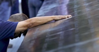 Joe Torres of Sayreville, N.J., a fire captain from Elizabeth, N.J., kneels as he touches the name of his sister-in-law, Krystine Bordenabe, during ceremonies marking the 11th anniversary of the 9/11 attacks on the World Trade Center in New York, September 11, 2012. Bordenabe, 33, was eight months pregnant when she was killed in the South tower. 