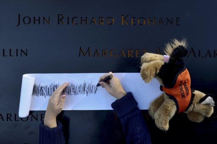 Ava Kathleen Schmoelzer, 7, makes a rubbing of her late aunt's name, Kathleen Moran, during ceremonies marking the 11th anniversary of the 9/11 attacks on the World Trade Center in New York, September 11, 2012.