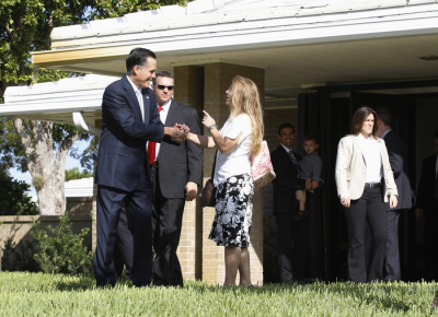 U.S. Republican presidential nominee and former Massachusetts Governor Mitt Romney stops to speak to congregants as he leaves a church in Boca Raton, Florida, October 21, 2012.