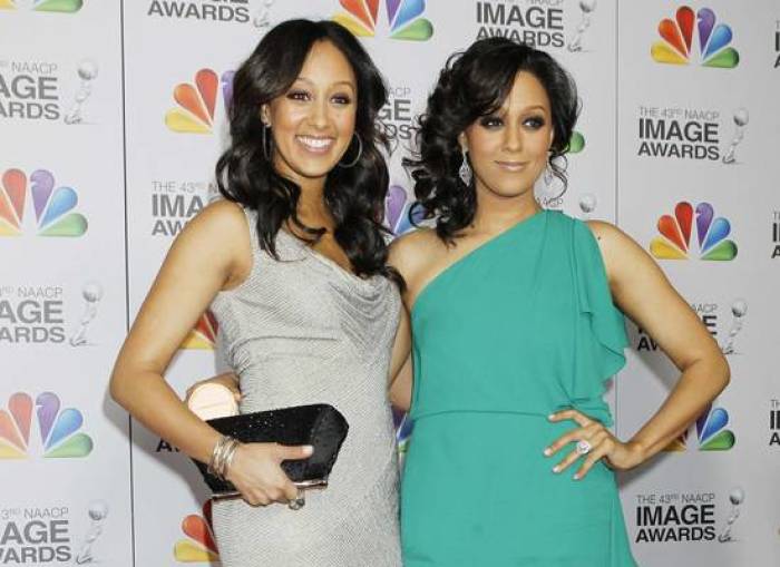 Actresses Tamera Mowry-Housley and her sister Tia Mowry arrive at the 43rd NAACP Image Awards in Los Angeles