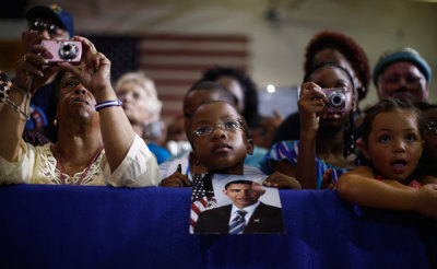 Kingston Stillwell Thomas, 9, listens to U.S. President Barack Obama as he holds a picture for him to sign during a campaign rally at Phoebus High School in Hampton, Virginia, July 13, 2012. Obama travelled to Virginia on Friday for campaign events.