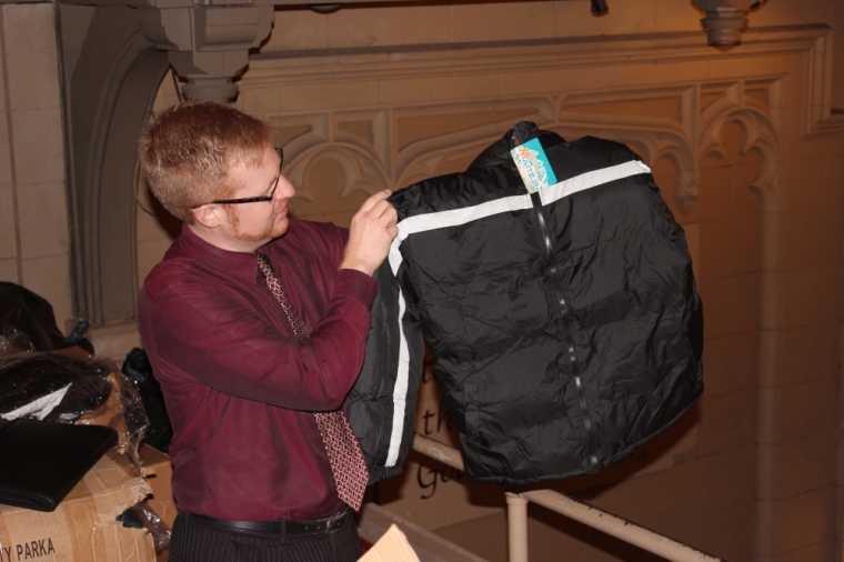 James Winans, the Chief Development Officer at The Bowery Mission holds up one of the coats that will be given to each guest on Thanksgiving Day - photo taken Nov. 19, 2012.