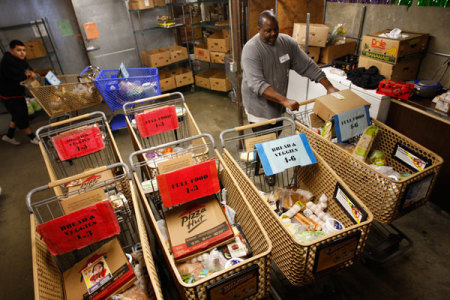 Workers fill carts with food for the poor at the Foothill Unity Center food bank in Monrovia, California, November 14, 2012. The number of people served by the Foothill Unity Center has tripled in the last four years. Groups that provide food for pantries say this is one of the toughest years yet in terms of low levels of federal government 'surplus' commodity donations, which have accounted for a major portion of meat and other proteins in the past. Those shortfalls are putting real pressure on low income families and individuals, who are more squeezed than ever because of still high unemployment, federal and state budget cuts, higher grocery costs from recent drought, rising rents and transport costs.