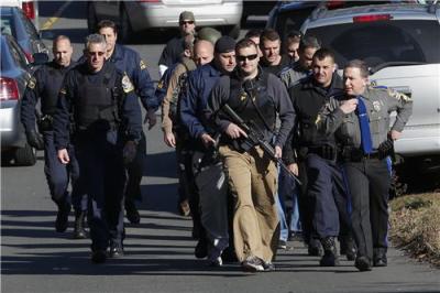 Police patrol the streets outside Sandy Hook Elementary School after a shooting in Newtown, Conn., Dec. 14, 2012. At least 27 people, including children, were reportedly killed on Friday when at least one shooter opened fire at an elementary school.