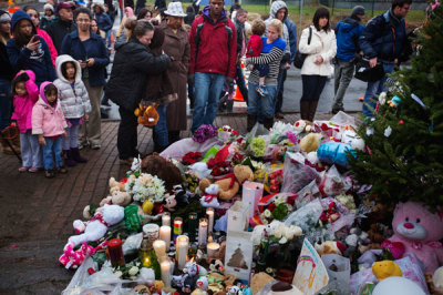 A mother hugs her daughter while visiting a memorial to the victims of the recent school shooting in Sandy Hook village in Newtown, Connecticut, December 16, 2012. Worshippers filled Sunday services to mourn the victims of a gunman's elementary school rampage that killed 20 children and six adults with President Barack Obama due to appear later at an interfaith vigil to help this shattered Connecticut town recover.