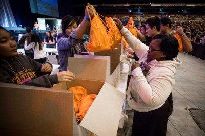 Students attending Urbana 12 place completed AIDS caregiver kits in boxes ready to be shipped to Swaziland and other African countries. The 32,000 kits filled with six essential items, such as latex gloves and soap, were completed in about two hours Saturday evening, Dec. 29, 2012.