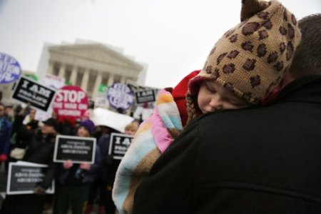 Paisley Fowles, aged one, of Naples, Florida, sleeps on her father's shoulder amidst the din of the annual March for Life rally at the U.S. Supreme Court building in Washington, January 25, 2013. The anti-abortion marchers on Friday marked the 40th anniversary of the Roe v. Wade U.S. Supreme Court ruling legalizing abortion, and Pope Benedict expressed support for the demonstrators.