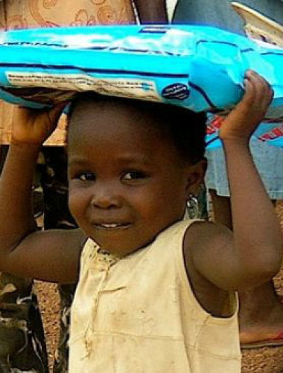 A child holds an insecticide-treated sleeping net distributed by HIS Nets in Ghana in 2009.