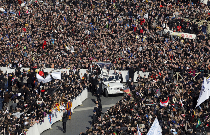 Pope Benedict XVI waves from his Popemobile as he rides through a packed Saint Peter's Square at the Vatican during his last general audience, February 27, 2013. The weekly event which would normally be held in a vast auditorium in winter, but has been moved outdoors to St. Peter's Square so more people can attend. The pope has two days left before he takes the historic step of becoming the first pontiff in some six centuries to step down instead of ruling for life.