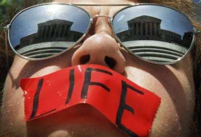 Anti-abortion activist Craig Kuhns wears mirrored sunglasses and a piece of tape over his mouth as he stands in front of the US Supreme Court building in Washington, June 1, 2009.