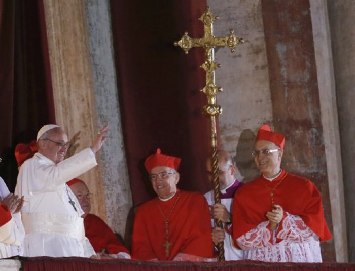 Newly elected Pope Francis (L), the former Cardinal Jorge Bergoglio of Argentina appears on the balcony of St. Peter's Basilica after being elected by the conclave of cardinals, at the Vatican, March 13, 2013. Francis delivered his first blessing to a huge crowd in St Peter's Square on Wednesday night, asking for the prayers of 'all men and women of good will' to help him lead the Catholic Church.