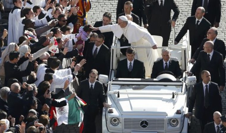 Pope Francis leans out to touch a child's head as he arrives in Saint Peter's Square for his inaugural mass at the Vatican, March 19, 2013. Pope Francis celebrates his inaugural mass on Tuesday among political and religious leaders from around the world and amid a wave of hope for a renewal of the scandal-plagued Roman Catholic Church.