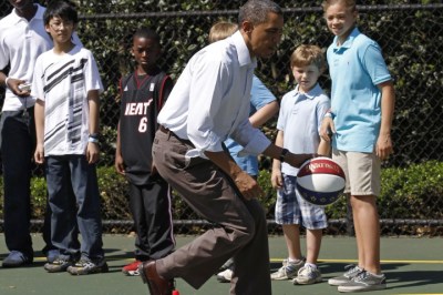 U.S. President Barack Obama dribbles the ball past some children while doing some basketball drills, during the annual Easter Egg Roll at the White House in Washington, April 25, 2011.