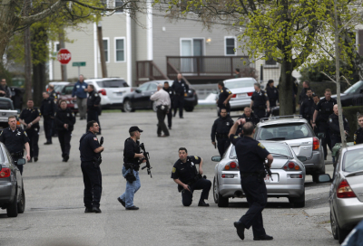 Police officers search homes for the Boston Marathon bombing suspects in Watertown, Massachusetts April 19, 2013. Police on Friday killed one suspect in the Boston Marathon bombing during a shootout and mounted a house-to-house search for a second man in the suburb of Watertown after a bloody night of shooting and explosions in the city's streets.