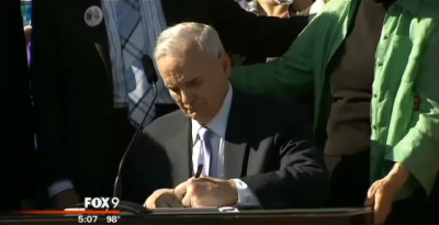 Minnesota Democratic Gov. Mark Dayton signs the Freedom to Marry bill on the Capitol steps. The law legalizes same-sex marriage and will recognize the marriages of same-sex couples who wed outside of the state starting on Aug. 1. St. Paul, Minn., May 14, 2013.