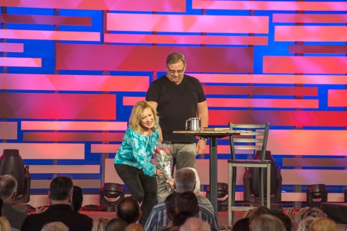 Credit : Kay Warren, wife of Saddleback Church pastor Rick Warren, receives a bouquet of roses prior to beginning the couple's message on maintaining hope in the midst of personal tragedy, July 27, 2013.