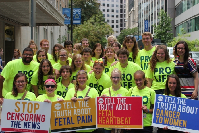 Thirty-six students, most of the forty who walked across America to protest abortion with the pro-life group Crossroads, stand in solidarity with their bright yellow shirts at the 'March On Media' protest Thursday, August 8, 2013, in Washington, D.C.