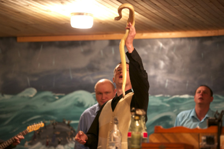 Pastor Andrew Hamblin of Tabernacle Church of God in LaFollette, Tenn., holds up an albino snake. Hamblin will not be criminally prosecuted for handling the snakes, but the confiscated reptiles will not be returned.