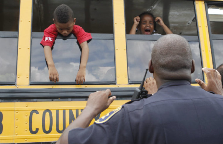 Sheriff's Deputy John Conley tries to calm children on a bus at a local Walmart following a shooting incident at McNair Discovery Learning Academy in Decatur, Ga., on Aug. 20, 2013.