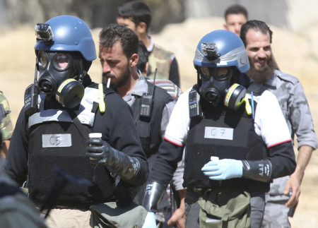 U.N. chemical weapons experts wearing gas masks carry samples from one of the sites of an alleged chemical weapons attack in the Ain Tarma neighbourhood of Damascus August 28, 2013. U.N. chemical weapons experts investigating an apparent gas attack that killed hundreds of civilians in rebel-held suburbs of Damascus made a second trip across the front line to take samples.