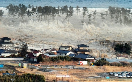 A massive tsunami sweeps in to engulf a residential area after a powerful earthquake in Natori, Miyagi Prefecture in northeastern Japan, on March 11, 2011. (Reuters/KYODO)