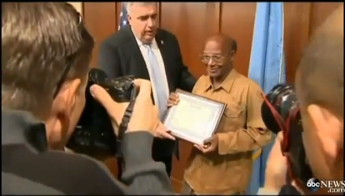 Homeless Boston man, Glen James (r) is honored by Boston Police Commissioner Edward F. Davis (l) for his honesty in returning a backpack filled with more than ,000 that he found.