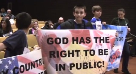 Students in Cranston, Rhode Island hold signs supporting religious freedom after atheist student Jessica Ahlquist filed a lawsuit against Cranston West High School regarding its prayer banner in 2011.