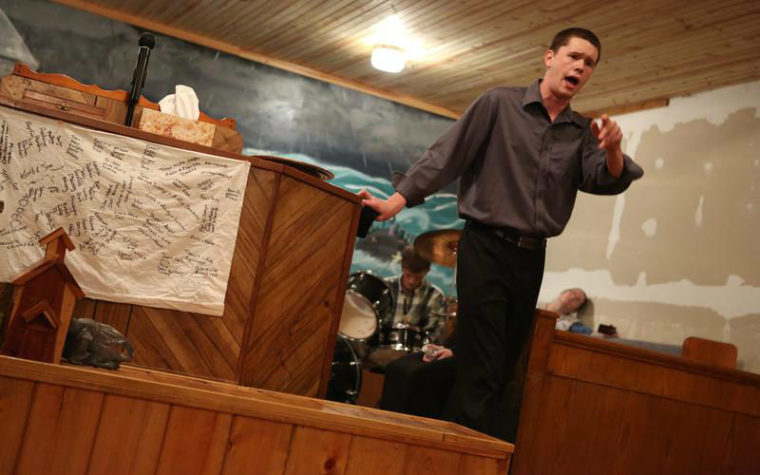 Andrew Hamblin points toward the crowd while preaching.