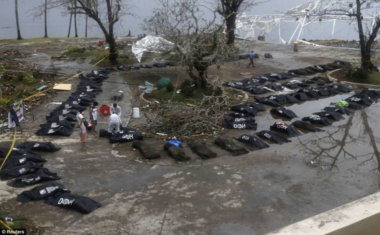 Police and military personnel remove bodies from the streets of Tacloban