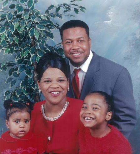 The late pastor Teddy Parker Jr. (far back), his wife Larrinecia Parker (center), and their two daughters Kamry (r) and Kerrington (l) in happier times.