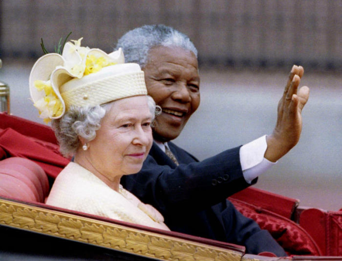 Nelson Mandela and Britain's Queen Elizabeth II ride in a carriage outside Buckingham Palace on the first day of a state visit to Britain, July 9, 1996.