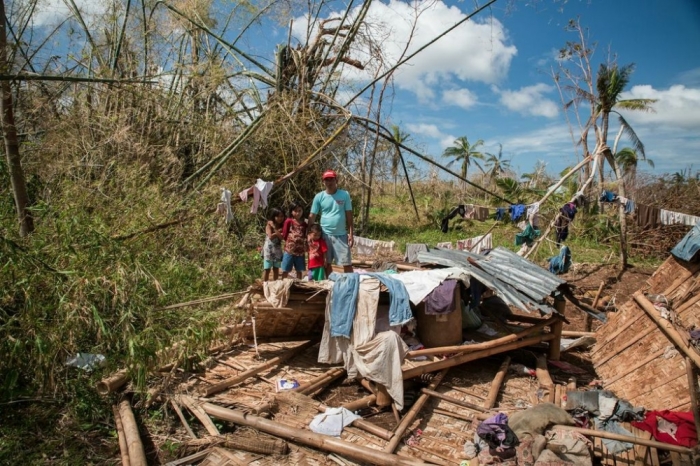 Rene Genosa and some of his children looking at the place where their home used to be. His wife, Edwina, gave birth to their daughter, Josephine, the day before Typhoon Haiyan hit the Philippines.