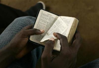 A boy turns a page of a bible during a mass, January 17, 2010.