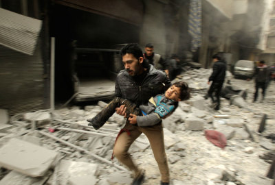 A man runs as he carries a child who survived from what activists say was an airstrike by forces loyal to Syrian President Bashar al-Assad, at al-Ferdaws in Aleppo January 21, 2014.