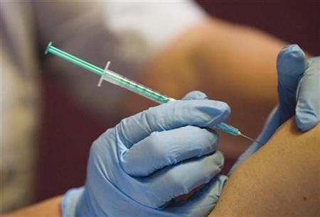 A medical assistant injects a vaccine in a file photo.