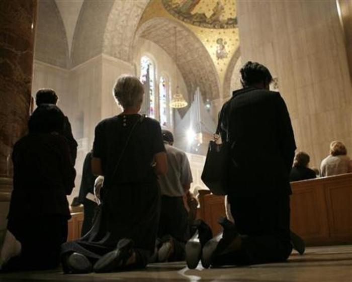 Catholics kneel during Mass in a file photo.