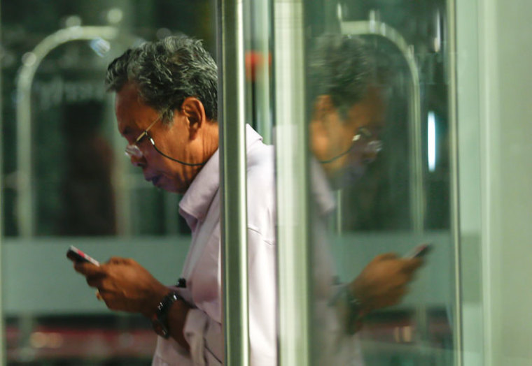 Selamat Omar, father of flight engineer Mohd Khairul Amri Selamat who was on board missing Malaysia Airlines flight MH370, is seen with his phone at a hotel where relatives of the passengers are staying, in Putrajaya March 24, 2014. The Malaysia Airlines plane that disappeared over two weeks ago crashed in the southern Indian Ocean, Malaysia's Prime Minister Najib Razak said on Monday.